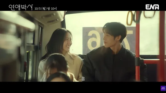 A young couple sitting closely on a bus, smiling at each other, with soft lighting and a warm atmosphere.