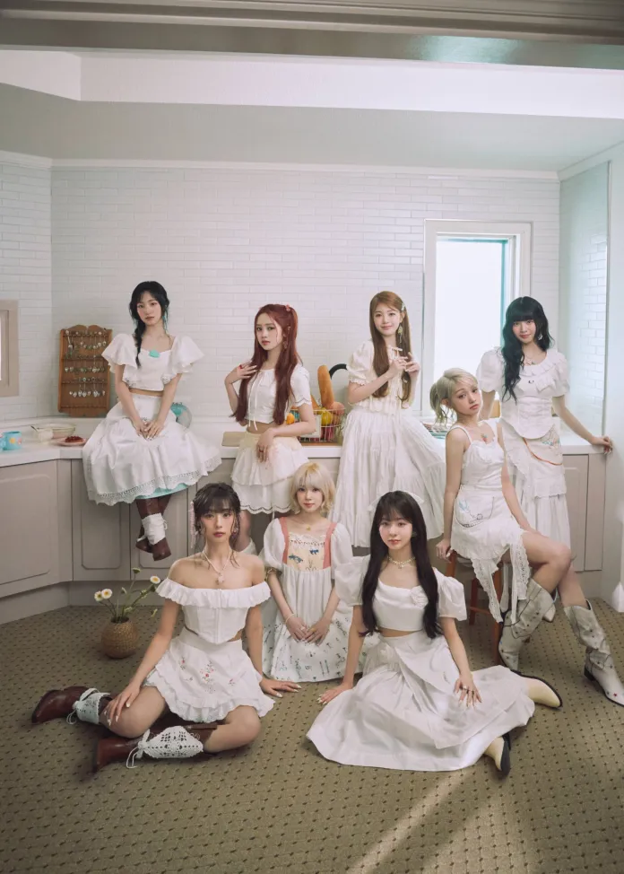 A group of nine individuals dressed in white outfits, posing together in a bright, cozy kitchen setting. The scene features a mixture of long and short dresses, with varying styles and accessories, creating a harmonious and elegant atmosphere.