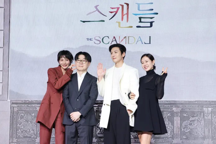 Four individuals posing for a promotional event for a show titled 'The Scandal', with a stylish backdrop.