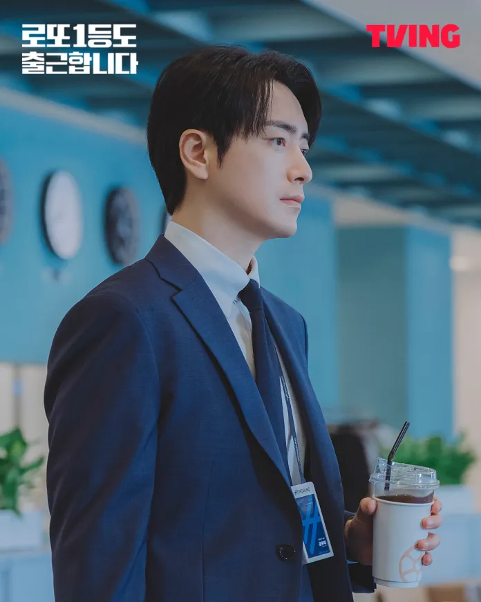 Lee Joon-hyuk in a suit stands in profile, holding a cold drink, with a serious expression. He is surrounded by a blue background with clocks and green plants visible.