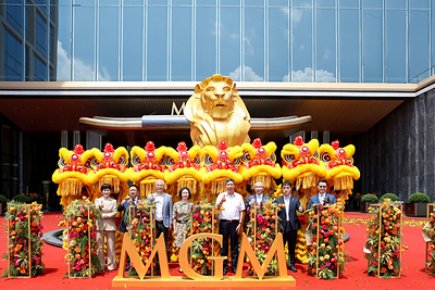 Representatives pose for a group photo during the grand opening of MGM Shenzhen Prince Bay with traditional lion dance performers.