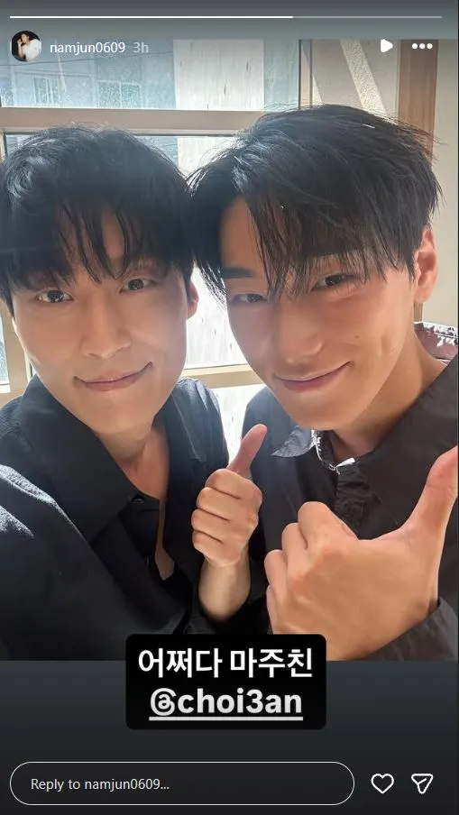 Heo Nam Jun and ATEEZ San smiling and giving thumbs up in front of a window, with natural light illuminating their faces.