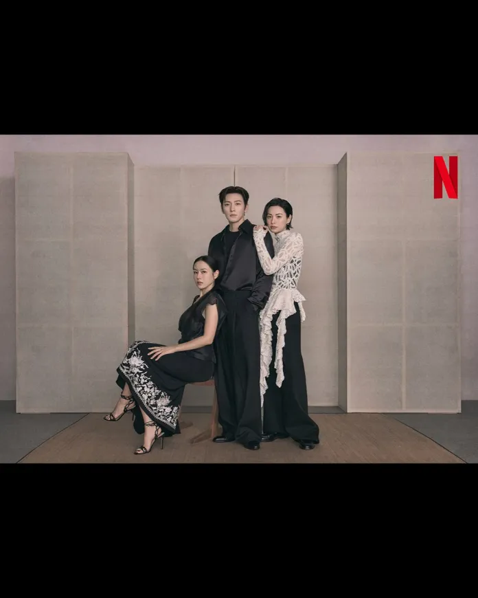 A stylish photoshoot featuring Son Ye-jin, Nana, Ji Chang-wook in fashionable attire, posed together against a neutral backdrop. Son Ye-jin on the left wears a black dress with white floral designs, while Ji Chang-wook in the center is dressed in all black, and Nana on the right is in a white lace outfit.