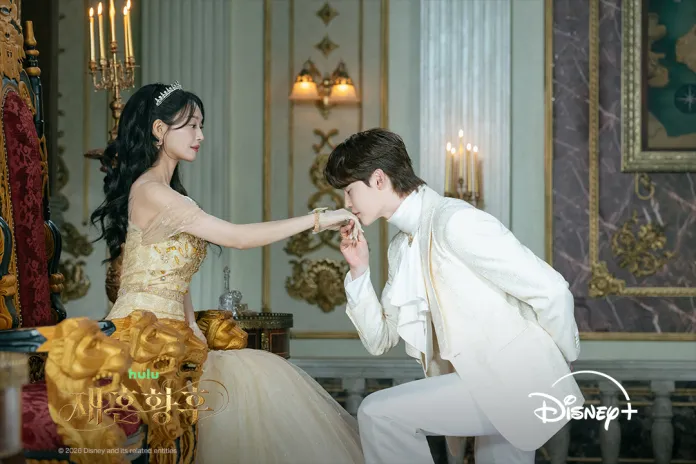 A scene depicting Shin Min-a in an elegant golden gown seated on a regal throne, extending her hand towards Lee Jong-suk in a white suit, who is poised to kiss her hand in a romantic gesture.
