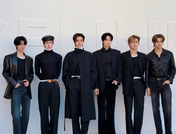 TWS members standing side by side, each wearing stylish black clothing including jackets and turtlenecks, with various accessories. They are posing in front of a plain white background with large letters.