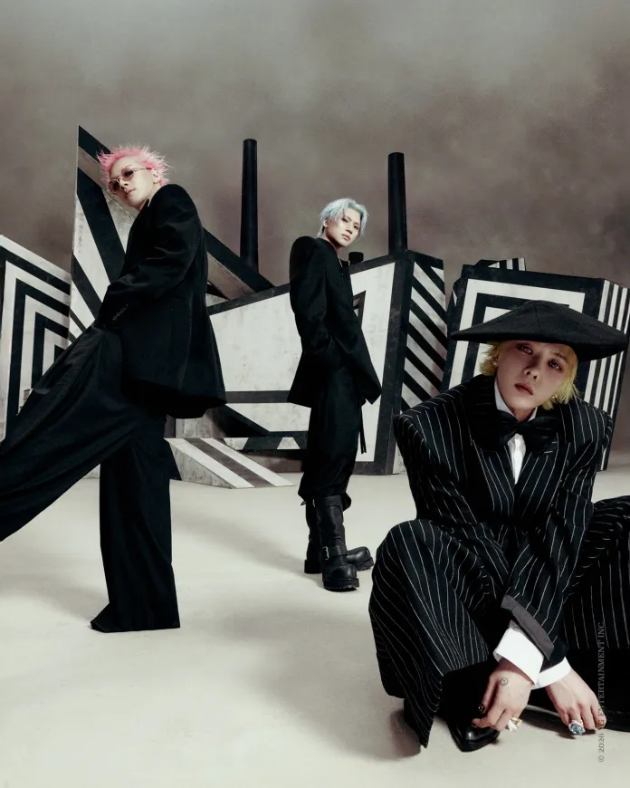 BigBang members in stylized black outfits posing dramatically against a geometric backdrop with bold stripes and patterns.