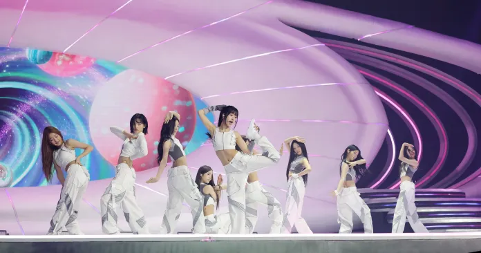 A2O LITE members performing on stage in futuristic outfits, with vibrant visual backgrounds and dynamic poses.