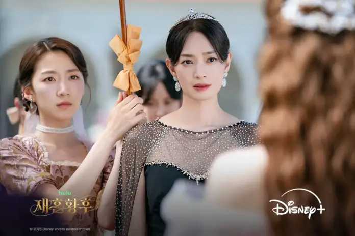 Shin min ah in formal attire with a tiara and delicate jewelry stands with a serious expression, while another woman holds an umbrella behind her, set in a luxurious outdoor location.