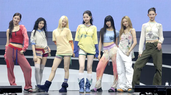 TUIDE members posing together on a stage, wearing colorful and stylish clothing, showcasing their unique fashion styles.