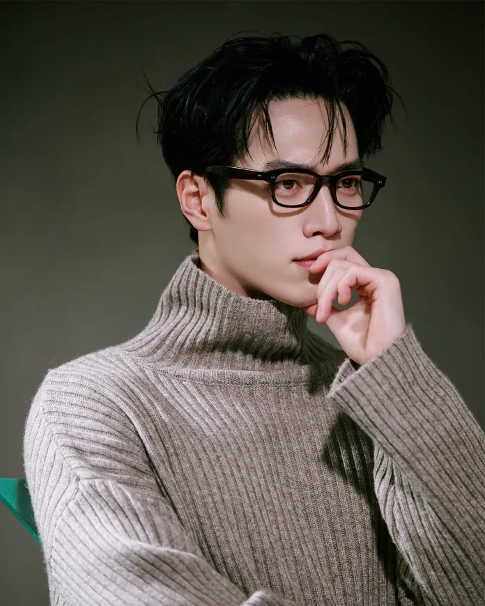 Seo Kang-joon wearing glasses and a ribbed turtleneck sweater, with dark hair styled casually, captured in a close-up portrait.