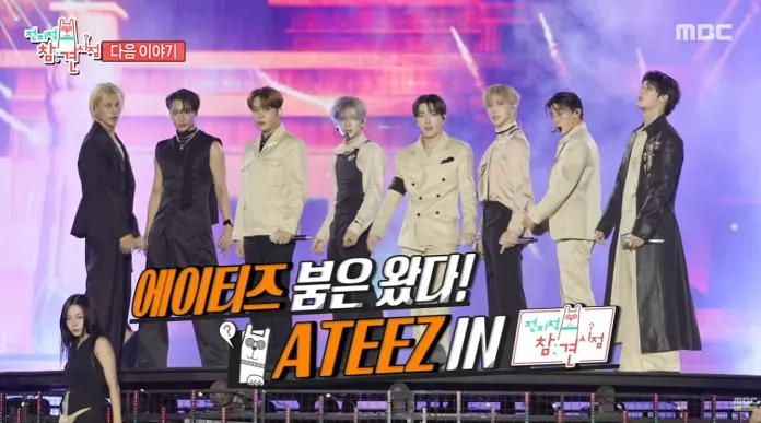 Ateez K-pop group ATEEZ on stage, dressed in stylish outfits, with colorful stage lights in the background.