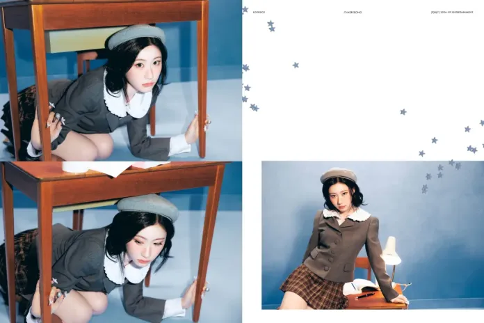 Chaeryeong in a stylish outfit with a white collar and a beret is playfully crawling under a wooden table. The setting features a blue background, and she is positioned in a way that highlights her expression and playful demeanor.