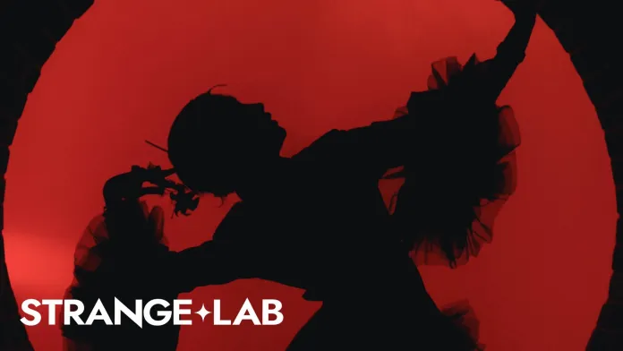 Silhouette of a dancer against a red background with dramatic lighting.