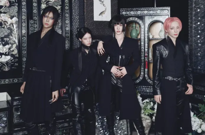 XLOV in dark, stylish clothing pose together in front of an ornate background with decorative elements. They showcase a mix of contemporary fashion and edgy aesthetics.