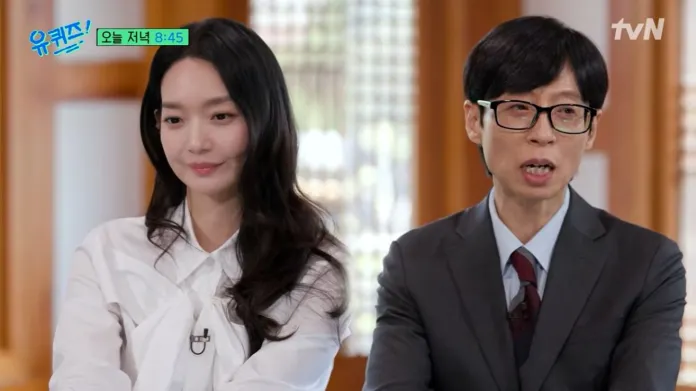 Shin Min-a with long hair in a white blouse. They appear to be engaged in a conversation in a bright, traditional setting.