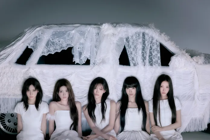 RESCENE members in white dresses sit in front of a car covered with white lace and fabric, set against a soft grey background.