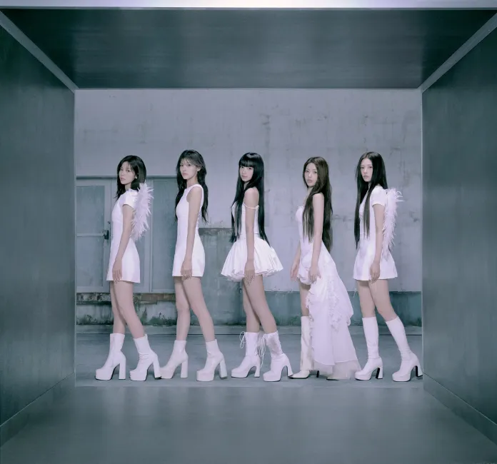 RESCENE members in stylish white outfits with high heels and unique designs, standing in a modern hallway with a minimalist aesthetic.