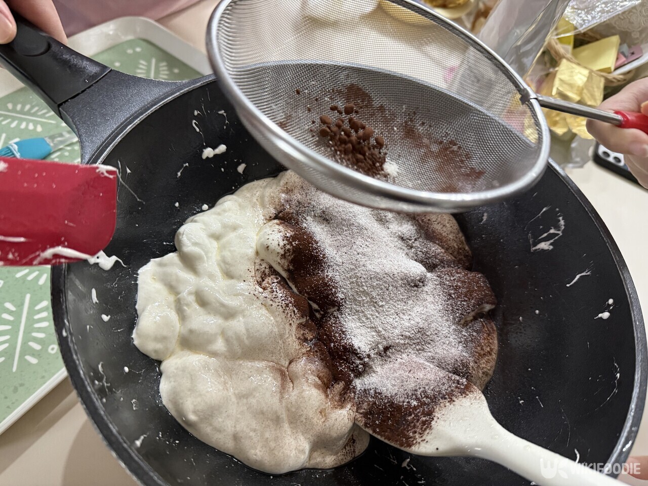 녹은 마시멜로에 코코아파우더와 탈지분유를 체에 걸러 넣고 있다. / 위키푸디