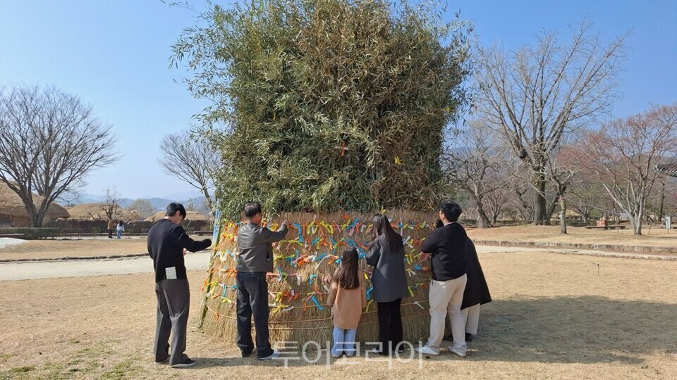 순천 낙안읍성 내 설치된 달집에 관광객들이 소원지를 달고 있다/사진-순천시