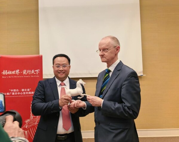 Photo shows Fang Junqin, Party Chief of Dehua County in southeast China's Fujian Province, presenting Dehua white porcelain to international guests in Geneva, Switzerland, on Feb. 24, 2026.