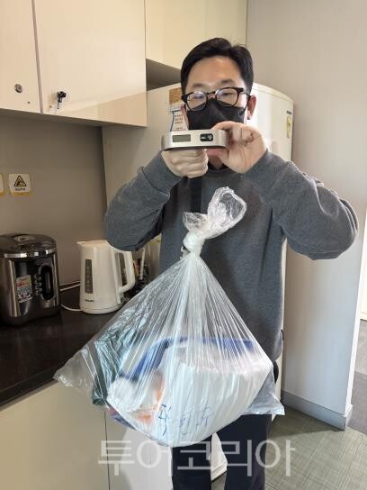 생활폐기물을 모아 휴대용 저을을 이용해 무게를 다는 모습 시연/사진=서울시