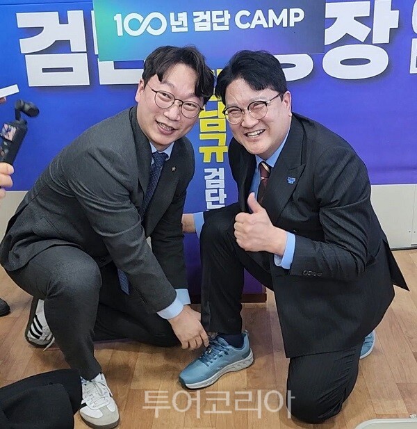 강남규 검단구청장 예비후보가 7일 오후 개최한 선거사무소 개소식에서 모경종 더불어민주당 국회의원이 강 예비후보에게 운동화를 신겨주고 있다.