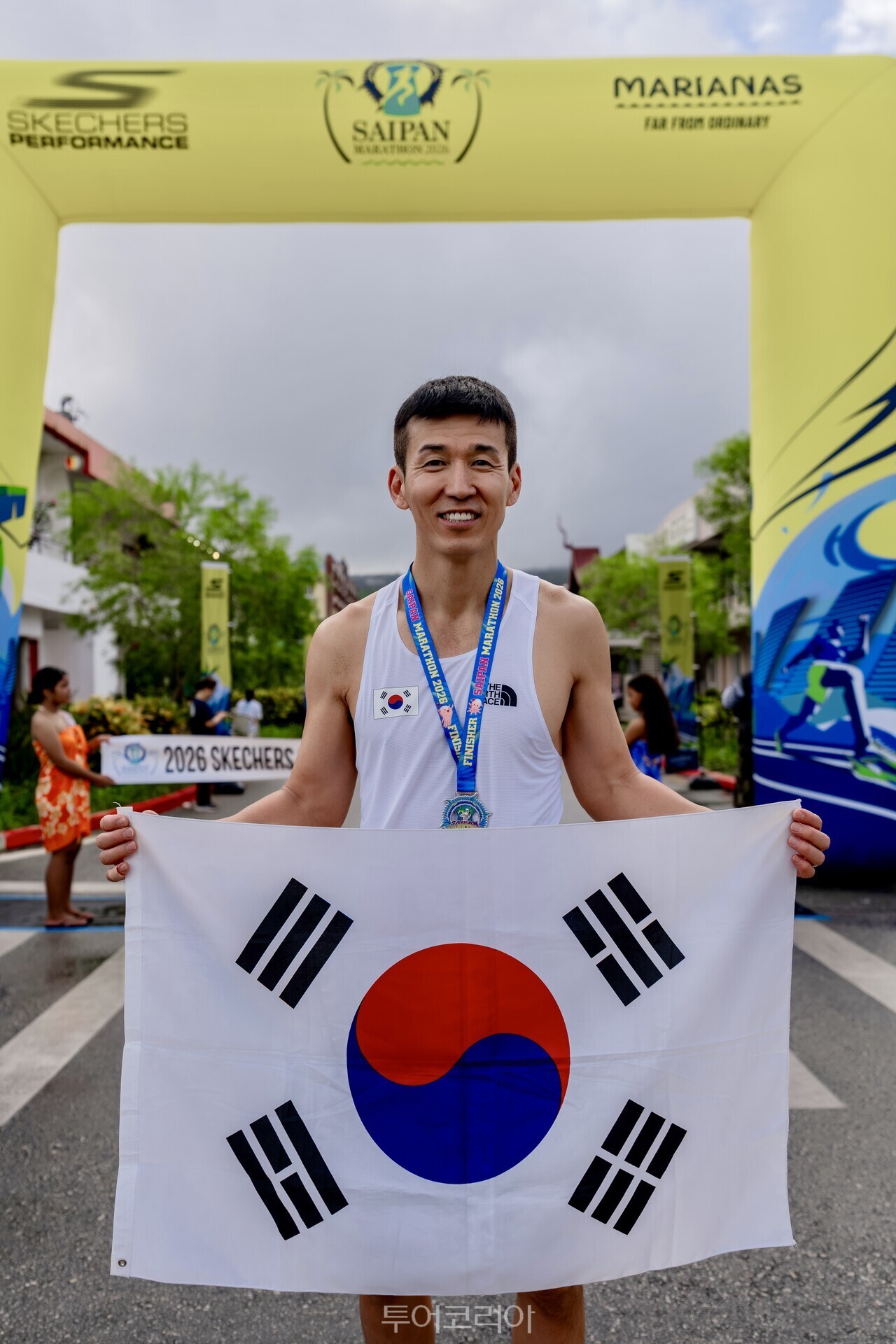 가수 션이 ‘사이판 마라톤 2026’ 현장에서 태극기를 들고 포즈를 취하고 있다./ 사진- 마리아나관광청