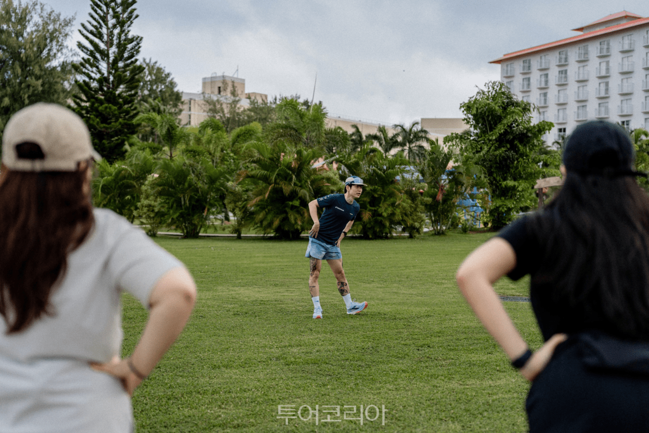 러닝 인플루언서 디어가 쉐이크아웃 런을 앞두고 참가자들과 함께 준비운동 스트레칭을 진행하고 있다./ 사진- 마리아나관광청