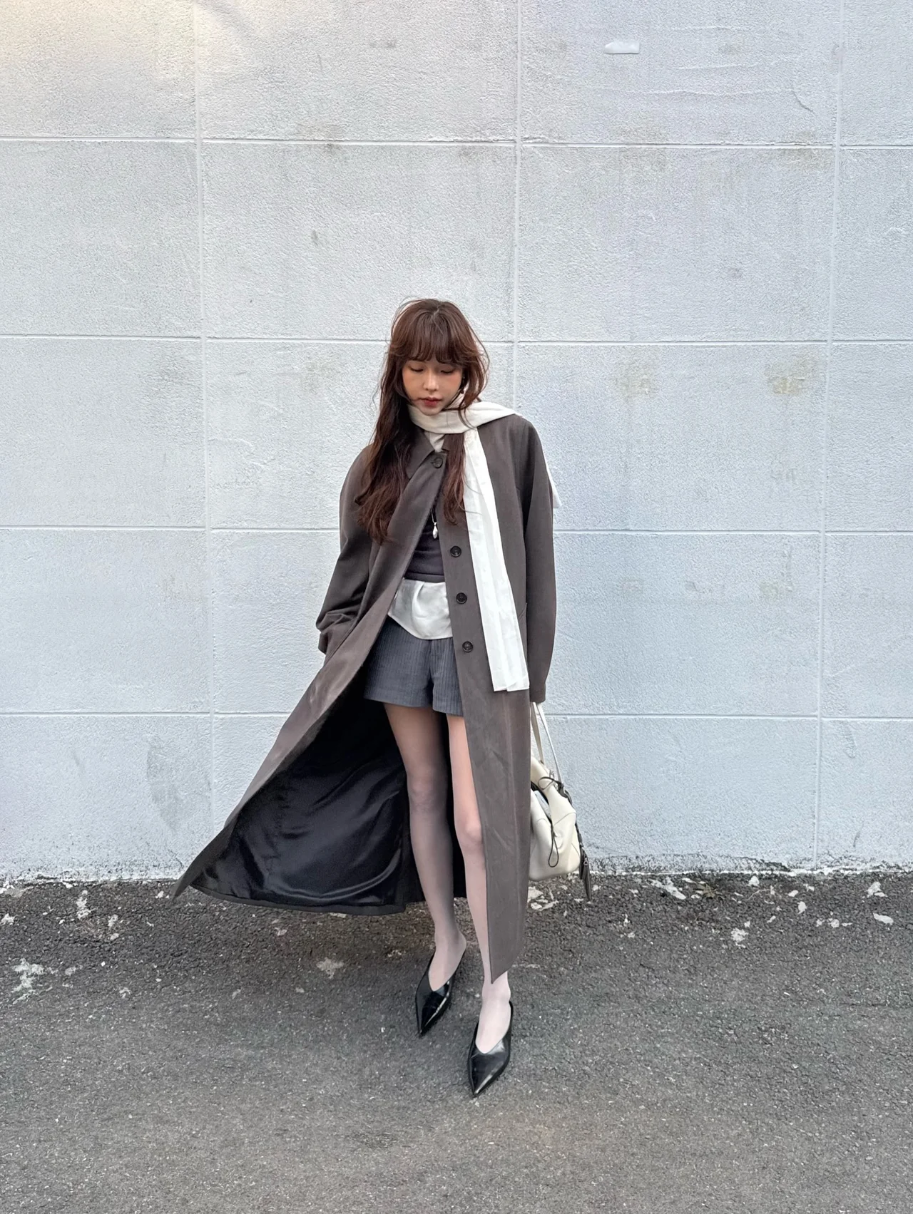 다크 모카 롱 오버코트에 그레이 미니 쇼츠, 화이트 스카프 드레이핑으로 완성한 환절기 레이어링 /사진=제현경 인스타그램