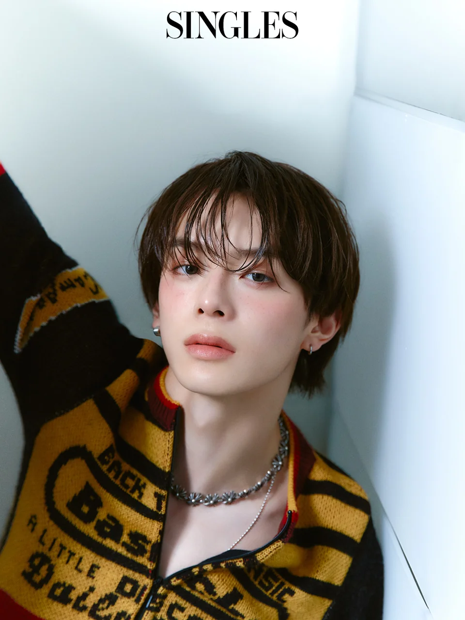 머스타드 옐로우 레터링 니트 집업과 실버 체인 네크리스, 후프 이어링의 클로즈업 뷰티 컷 /사진=싱글즈