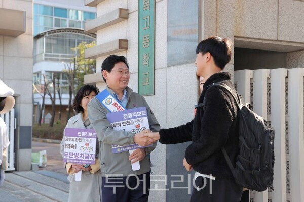 학교 정문에서 교통안전 캠페인 펼치는 이상일 시장이 학생과 웃으며 인사하고 있다/투어코리아뉴스 정명달 기자
