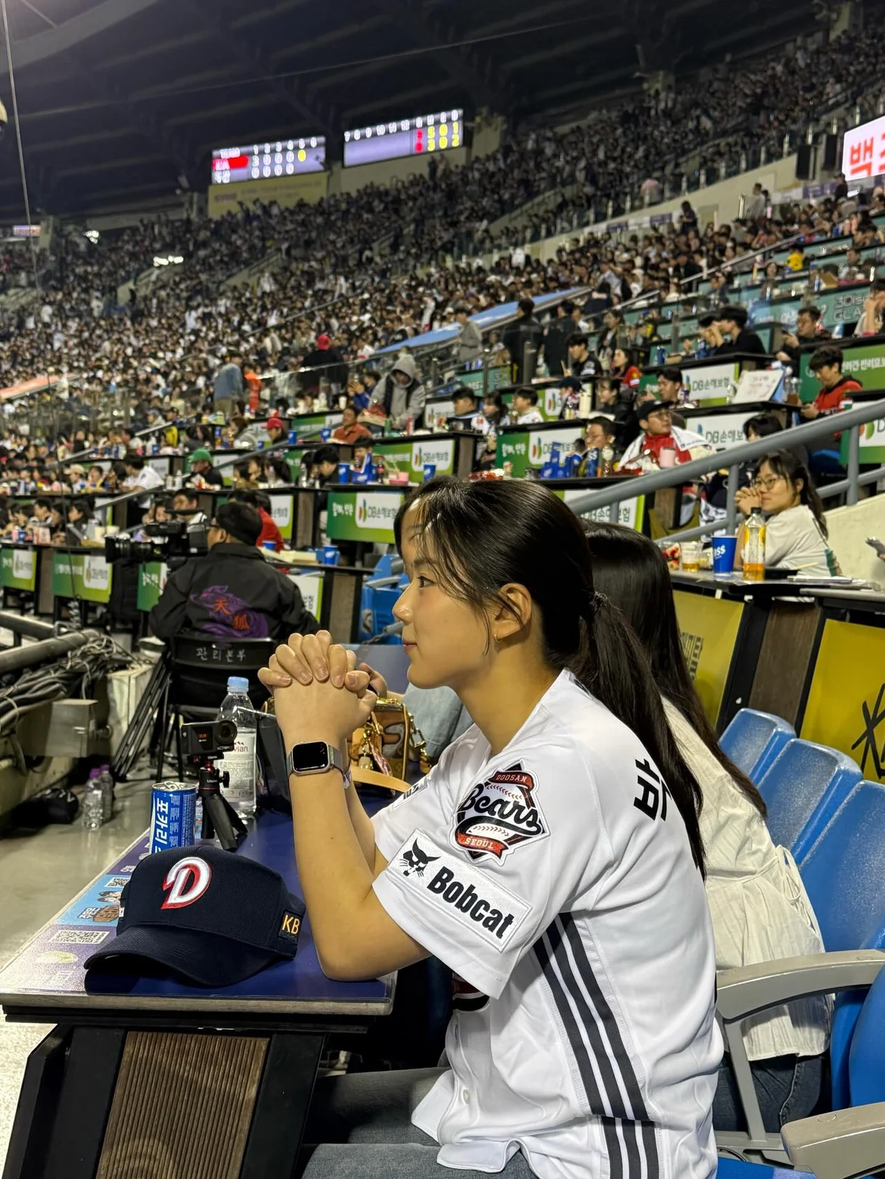 두산 베어스 홈 유니폼 착용, 잠실야구장 관중석에서 경기를 집중해서 보는 측면 컷 / 사진=박주아 인스타그램(@juuxu_aa_13)
