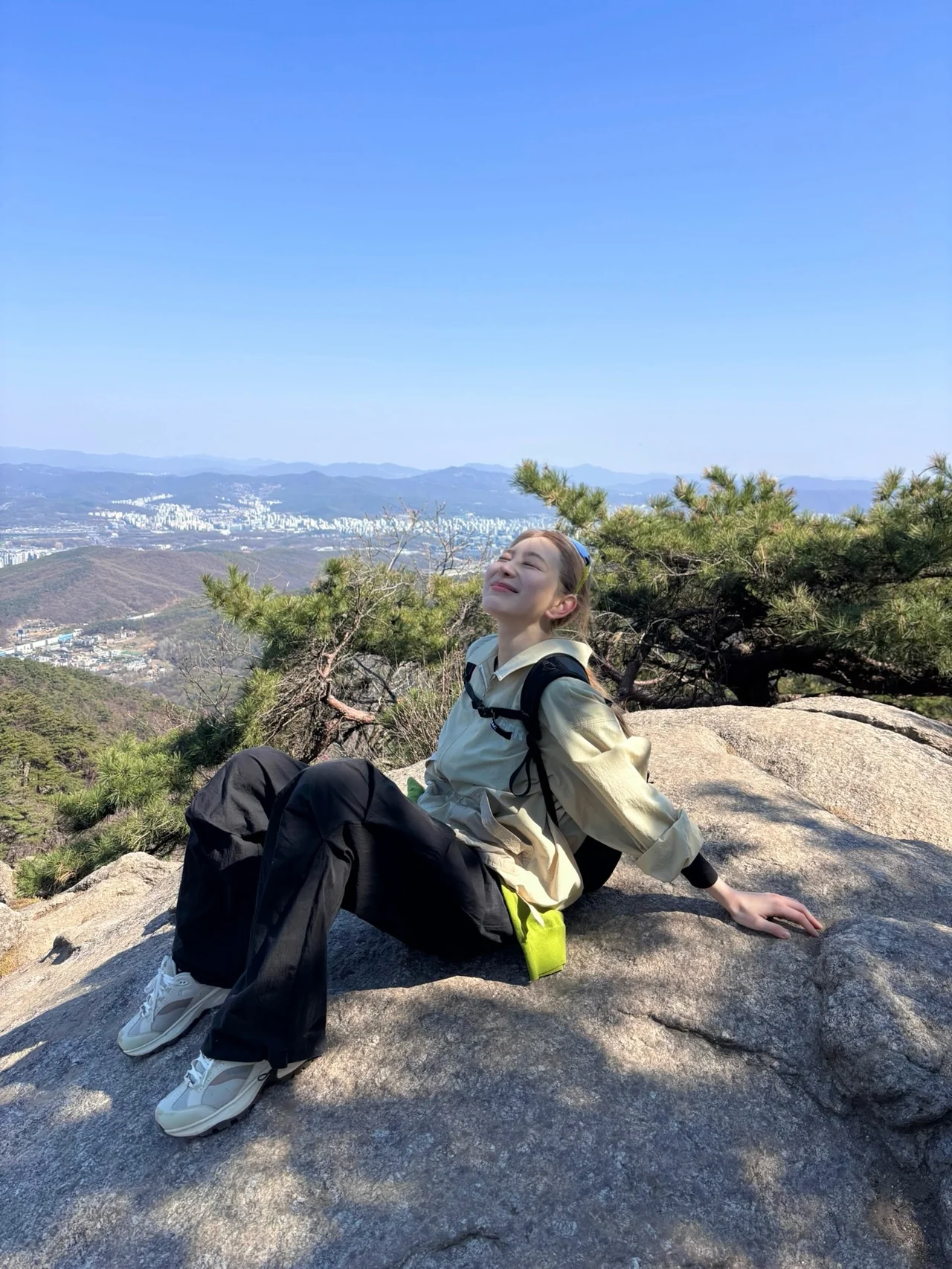 봄 산 정상 배경 베이지 윈드브레이커 + 블랙 팬츠 전신 등산 코디 / @chaestival_