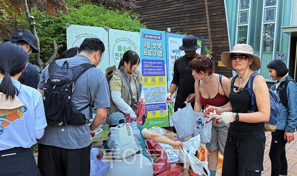 사진 / 하산 후 주운 쓰레기 분리수거하는 외국인 탐방객들의 모습_북한산국립공원도봉사무소 제공