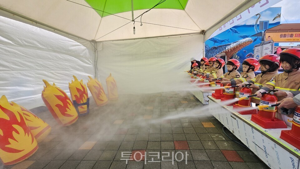 어린이들이 화재시 소화기 를  다루는  법을 직접 체험을 통해 배우고 있다./사진=유경훈 기자