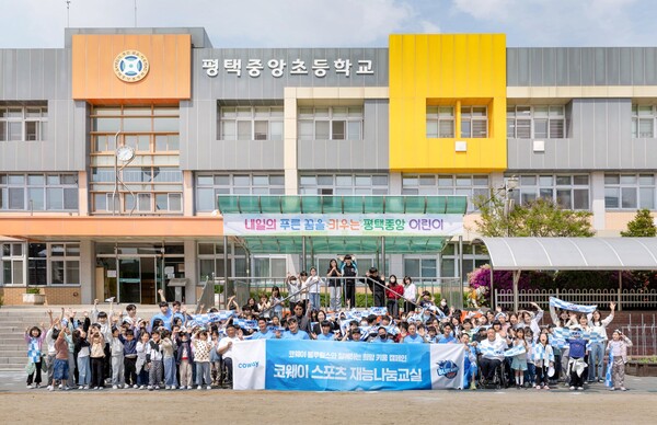 코웨이 블루휠스 휠체어농구단 선수 및 관계자들이 평택중앙초등학교 학생들과 휠체어농구 체험교실 진행을 기념해 단체사진을 촬영하고 있다.(사진=코웨이 제공)