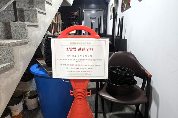 A 대표가 운영하는 와인 매장 앞에 K 회장 측이 집기를 쌓아 통로를 막은 모습. 건물 관리실에서 물건을 치워 달라고 요청하는 안내문을 붙여 놨다. A 대표는 소방법 위반이라며 관할 소방서에 해당 사실을 신고했지만, K 회장은 별다른 조치를 취하지 않았다. A 대표는 "다시 신고를 하고 소방관이 출동해 집기들을 철거했다"고 설명했다. (사진=A 대표 제공)
