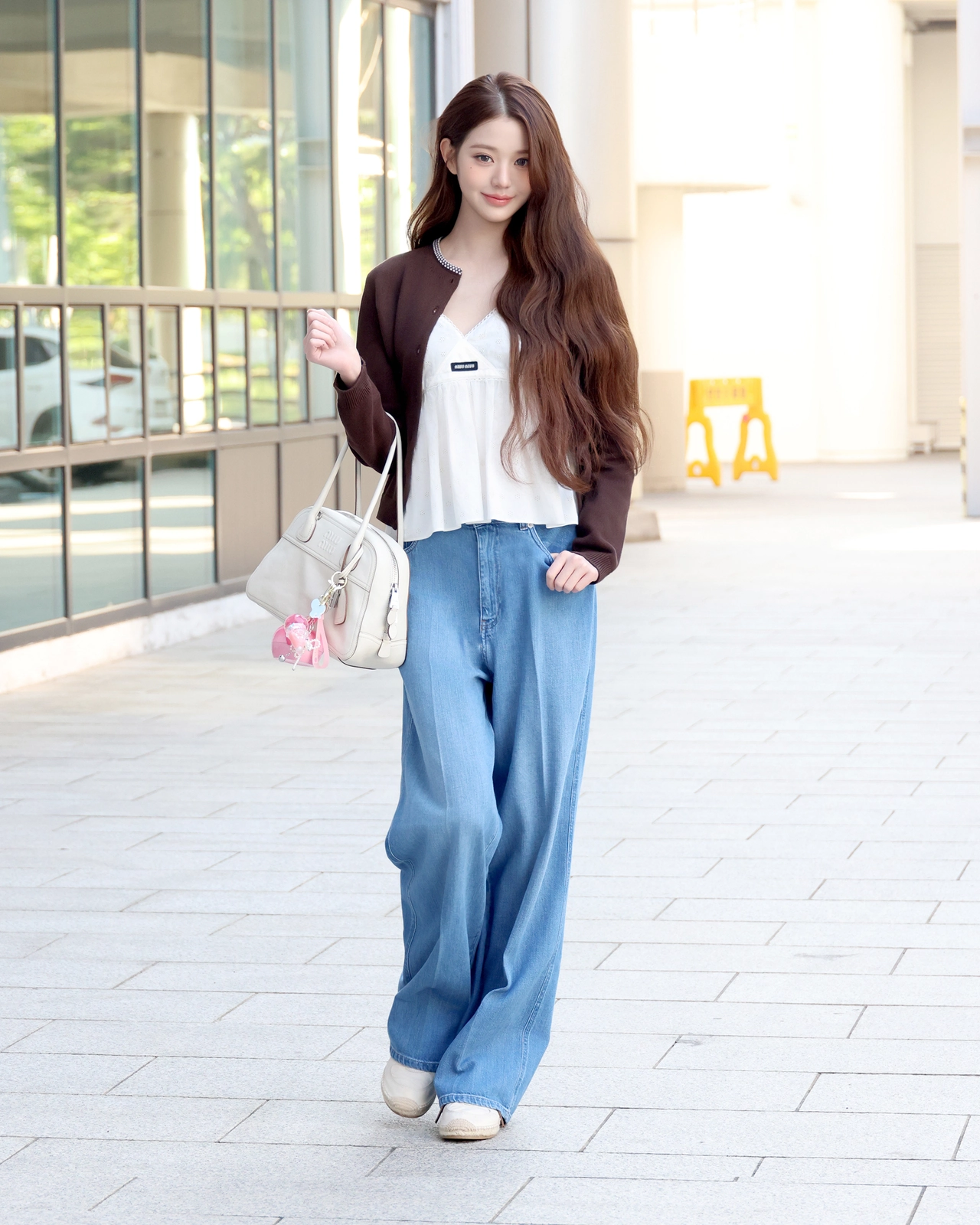 화이트 비방 나파 가죽 백과 핑크 키링 포인트가 담긴 전신 컷 / 사진=미우미우(Miu Miu)