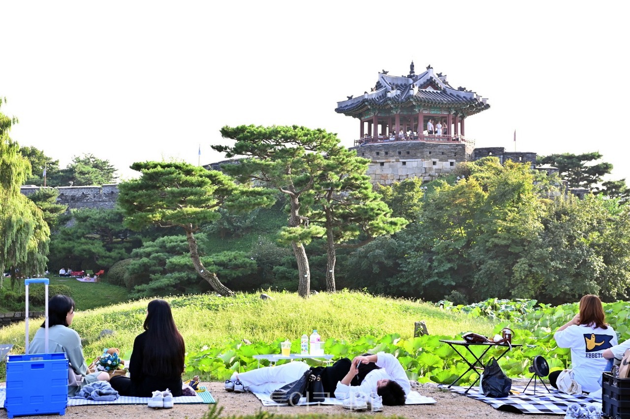  수원화성 방화수류정이 보이는 용연에서  피크닉을 즐기고 있는 사람들/사진-수원시