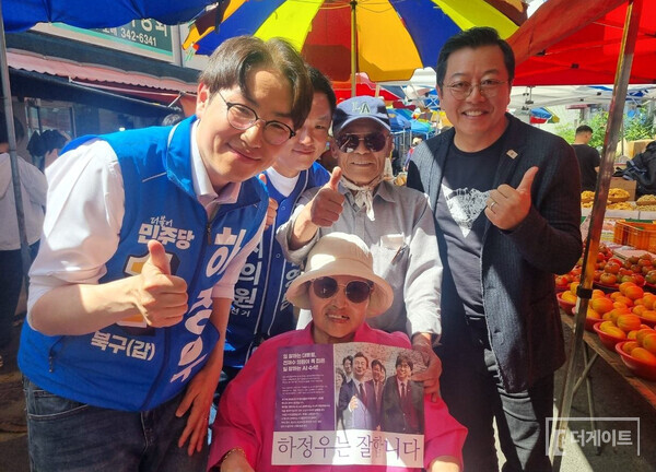 하정우 부산 북구 갑 후보(사진 왼쪽부터), 문영남 북구 제1선거구 시의원 후보가 부산 시민, 이기영 배우와 함께 기념촬영하는 장면(사진=더게이트)