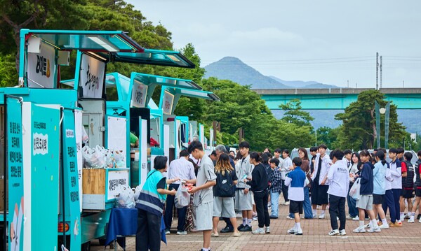 23일 부산 강서구 강서체육공원에서 전국소년체전 참가자들이 배달의민족과 주요 외식 브랜드가 함께 마련한 푸드트럭에서 음식을 받고 있다.(사진=우아한형제들 제공)