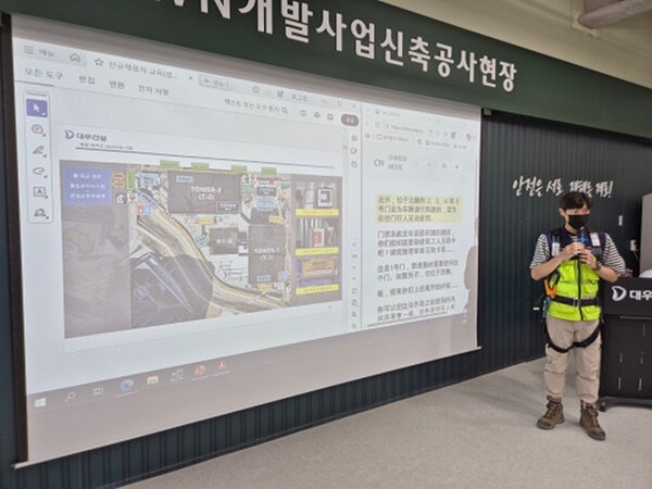 대우건설 관계자가 과천 G-TOWN 개발사업 신축공사 현장에서 외국인 근로자를 위한 AI 번역기 기능에 대해 교육 중이다.(사진=대우건설 제공)
