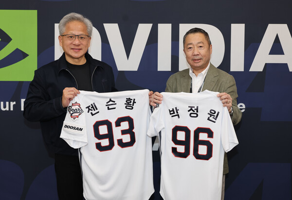 7일 잠실야구장을 방문한 박정원 두산그룹 회장(오른쪽)과 젠슨 황 엔비디아 CEO가 등번호 96번과 93번이 적힌 두산 베어스 유니폼을 들고 기념사진을 촬영하고 있다. 96번은 두산그룹 창립연도인 1896년을, 93번은 엔비디아 창립연도인 1993년을 의미한다.(사진=두산그룹 제공)