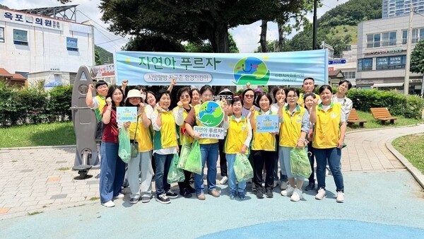 신천지자원봉사단 거제지부가 지난 9일 거제 옥포시장에서 ‘자연아 푸르자’ 환경정화 캠페인을 펼치고 있는 가운데 봉사자들과 기념 촬영을 하고 있다/사진제공= 신천지자원봉사단 거제지부.