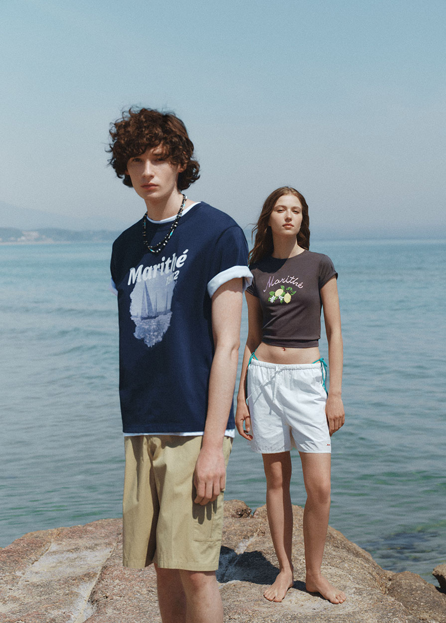 마리떼 프랑소와 저버 2026 핫 서머 캠페인 'Summer Arrives' 컷. 남녀 모델이 바다를 배경으로 그래픽 티셔츠와 쇼츠를 착용하고 있다. / 사진=마리떼 프랑소와 저버