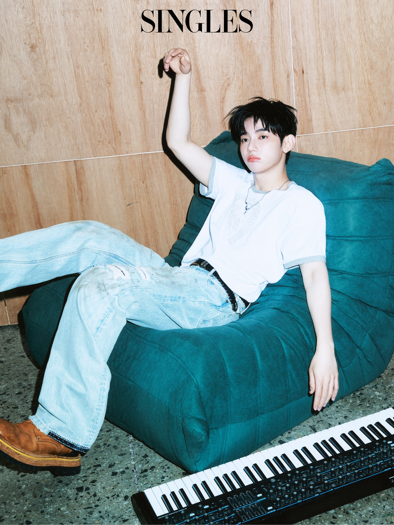 장하오가 싱글즈 7월호 화보에서 화이트 티셔츠와 라이트 블루 데님 팬츠를 착용하고 빈백 소파에 기대어 포즈를 취했다. 옆에는 키보드가 놓여 있다. / 사진=싱글즈