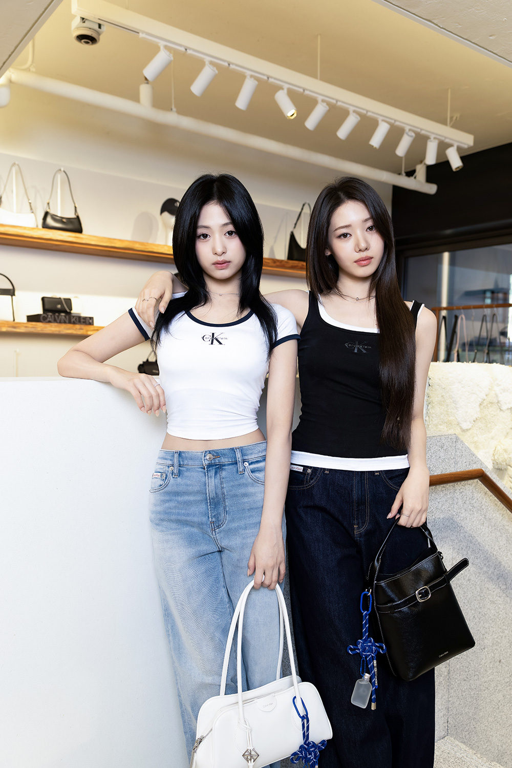 베이비몬스터 아현(왼쪽)과 로라가 캘빈클라인 성수 스토어 매장 내에서 각자의 아이템을 들고 포즈를 취하고 있다 / 사진=캘빈클라인
