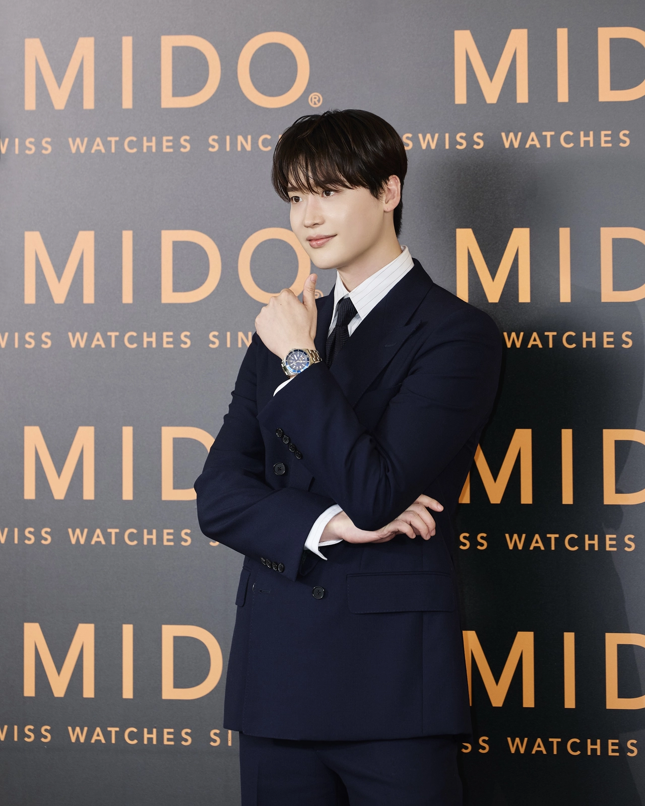 이종석이 미도 포토월 앞에서 네이비 수트를 입고 오션 스타 200 시계를 손목에 착용한 채 포즈를 취하고 있다 / 사진=미도