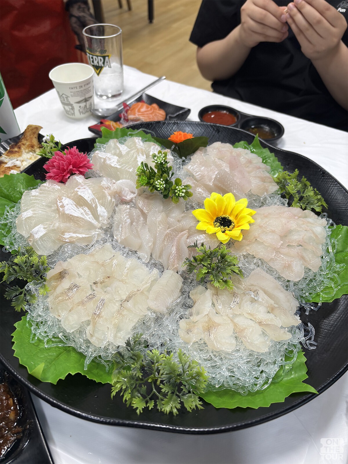 두툼하게 썬 회가 접시에 담겨 있다. / 온더투어