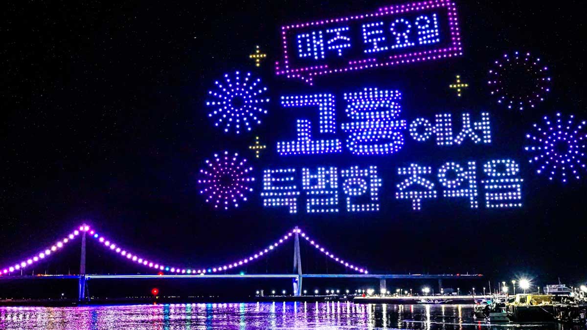 고흥 녹동항 밤하늘에 드론쇼 문구와 불꽃 모양이 떠오르고, 바다 위로 야간 조명이 비치고 있다. / 고흥관광